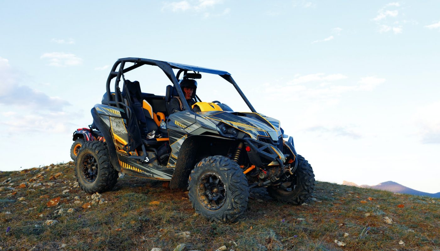 Man in helmet sitting on ATV quad bike in mountains